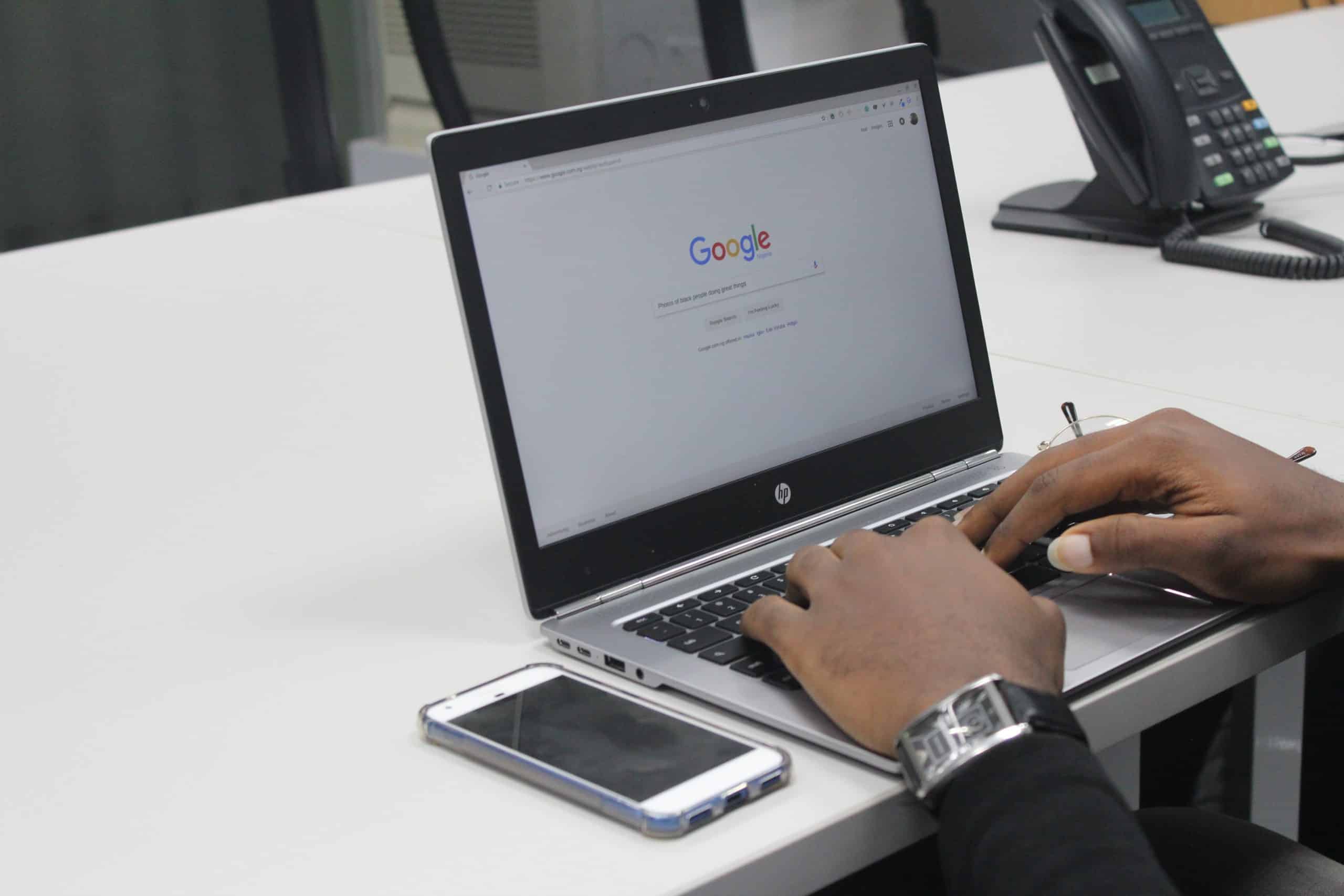 A man typing on a laptop at a desk.