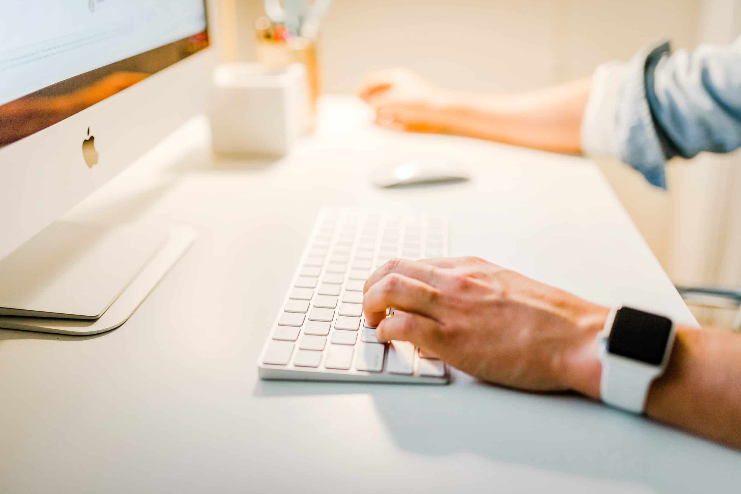 A person typing on a computer keyboard.