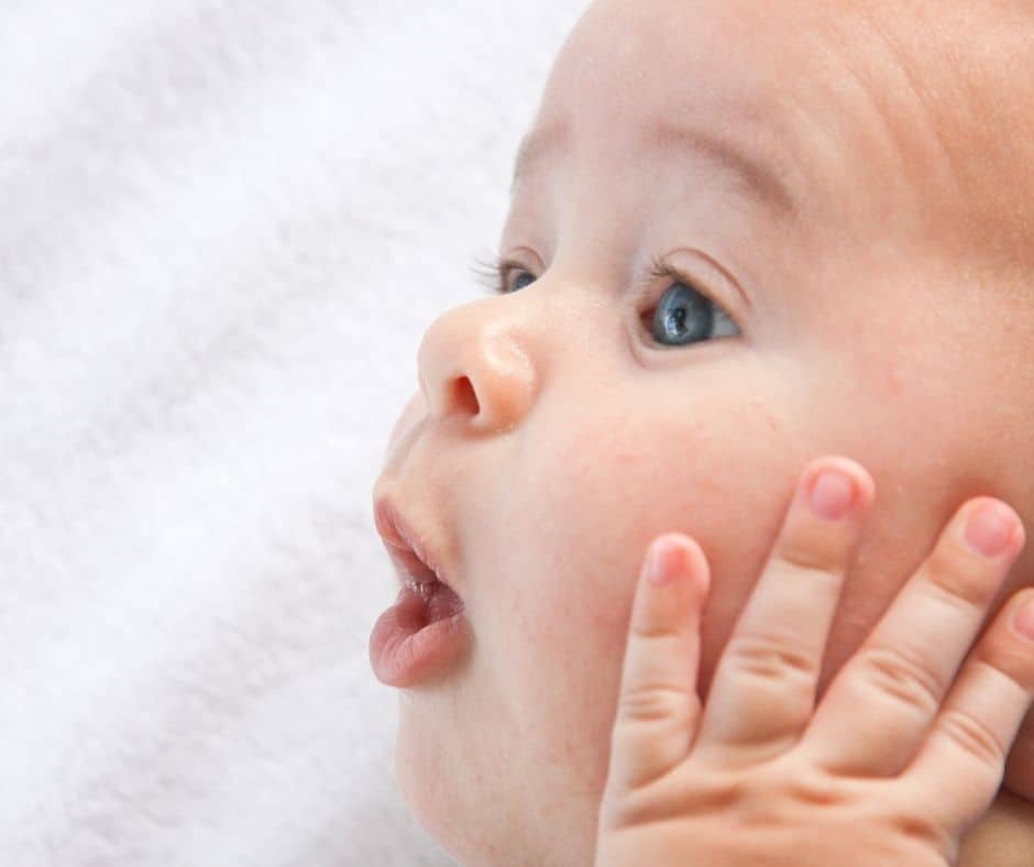 A baby's face looking up at the camera.